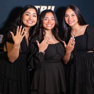 Three senior students show off their rings at ETBU's ring blessing ceremony