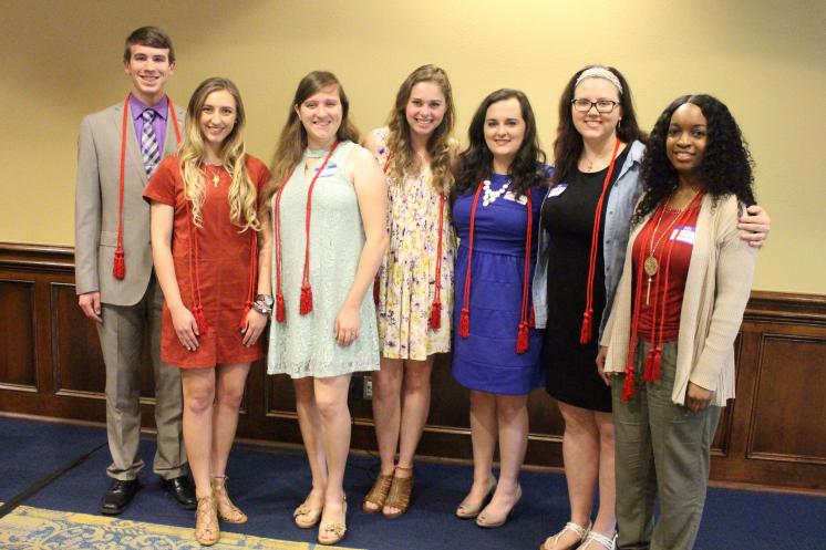 A group photo of Theta members receiving their graduation cords. 