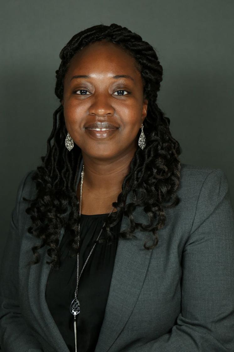 Woman smiling at the camera with a grey background