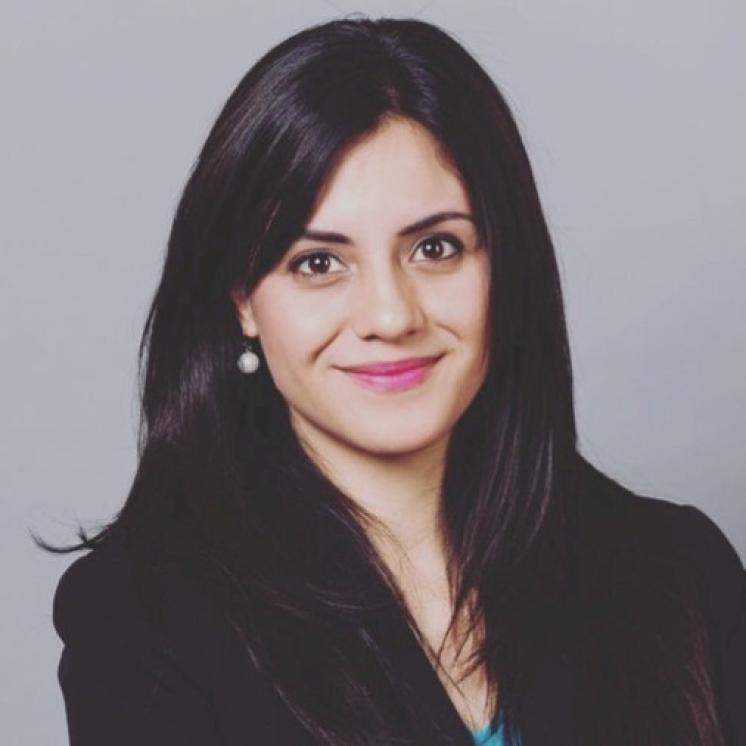 Woman smiling at the camera with a grey background